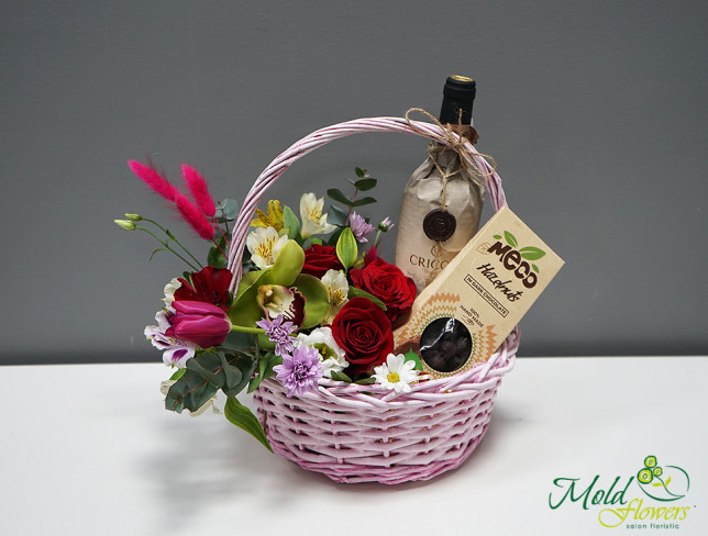 Coș cu flori, vin și bomboane de ciocolată foto